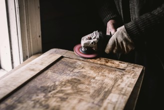 Close view of hands using a power tool for woodworking