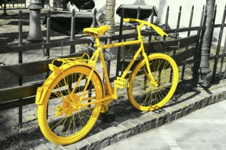 Colorful vibrant yellow color bicycle on the gray monochrome background