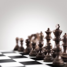 Strategy and tactics concept, black wooden chess figures on the board standing in a row ready for