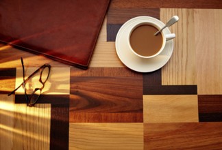 Coffee cup with glasses and leather folder on table retro vintage