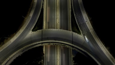 Aerial drone top view of a modern motorway junction roundabout with cars moving fast.