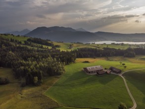 A farm in the Swiss Alps photographed from the air at sunset