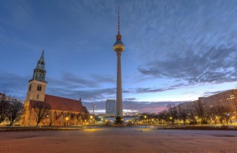 Alexanderplatz in Berlin with the famous television tower and St Mary's Church in front of sunrise