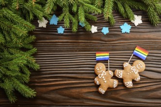 Christmas background of gingerbread man with flag spruce branches and colorful sugar snowflakes on