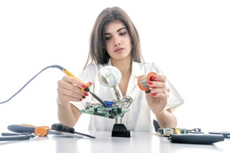 Woman Electronic Technician Repair Electronic Equipment using Electric Soldering Iron
