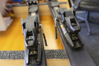 Ski center repair service shop, adjust the bindings and boots equipment on the table. Winter rent