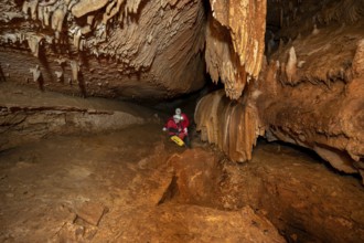 A group of speleologist inside a cave, illuminated by headlamps, exploring the depths of a