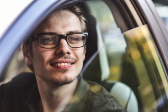 Enjoy the drive. Image of young handsome guy sitting in car