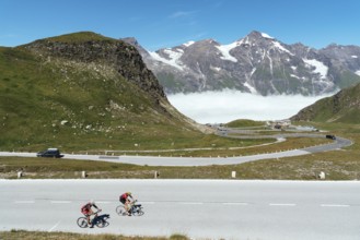 Grossglockner, Austria, August 7, 2017: Cyclists climbing mountain pass by Alpine road through