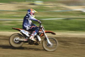 Unrecognized athlete riding a sports motorbike on a motocross racing event. Exreme sports high