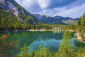 Green water reflects the surrounding mountains and forest. Magnificent lake Lago di Braies. South