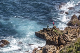 Two fishers on a rock at Cape Spartel near Tangier, Morocco, Africa
