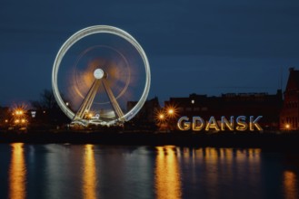 Gdansk Poland Ferris wheel in the old town of Gdansk at night evening dusk Reflection in river