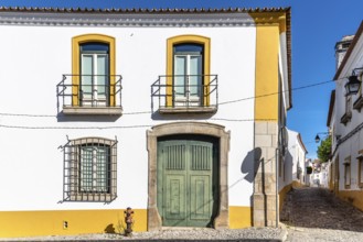Cityscape of Evora with typical houses painted in white and yellow. Alentejo, Portugal, Europe