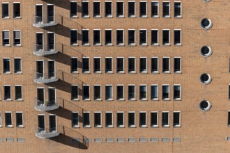 Red brick building with balconies and square and round windows in the Speicherstadt, Hafencity,