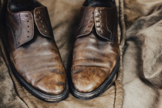 A pair of worn brown leather shoes with a vintage and rustic aura
