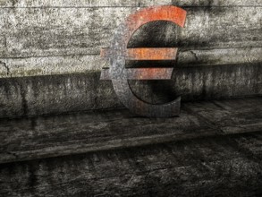 Symbol of decline: a rusty euro in front of weathered concrete