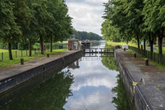 A lock on a quiet canal with a boat and trees on the banks, Dortmund-Ems Canal, Emsland, Lower