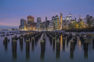 Illuminated Skyline of Lower Manhattan and River with Piers at Twilight. New York City