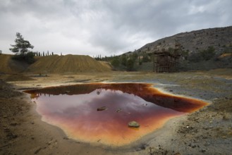 Lake with red polluted toxic water of an Abandoned copper mine at Mitsero area in Cyprus