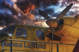 Old yellow aeroplane with propeller and a dramatic cloudy sky at sunset, Aero Commander 680E