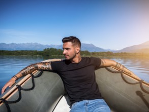 Portrait of young bearded handsome man with tattooed body looking sexually at camera sailing in