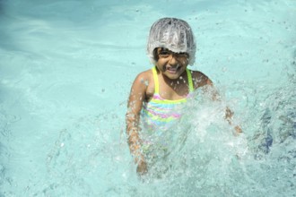 Little girl splashing water in swimming pool, Raigad, Maharashtra, India, Asia, MR#736LA, Asia