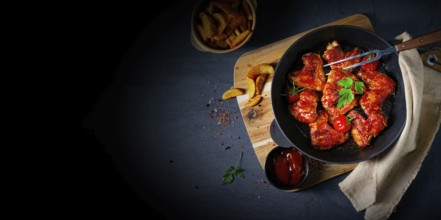 Savoury chicken wings in honey with potato wedges