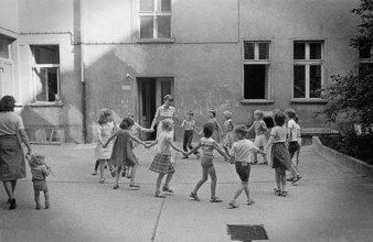 26/04/1983 GDR East Berlin district of Prenzlauer Berg. Children dancing in a circle with their