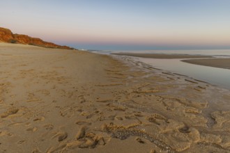 What a sandy beach on the Atlantic. Landscape shot at sunset on a coast with sandstone cliffs. Low