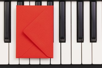 Funny arrangement envelope on the piano keybords - Flat lay image