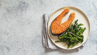 Ready-to-eat grilled salmon steak and greens - baby broccoli or broccolini and spinach on rustic