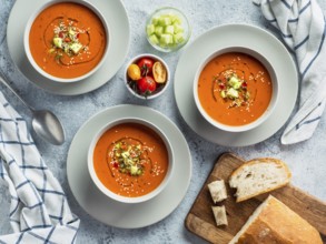 Gaspacho soup on white marble tabletop. Three bowls of traditional spanish cold soup puree gaspacho