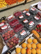 Budva, Montenegro - 25 december 2022: Fresh lychee berries, peaches, currents, raspberry