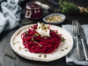 Beetroot pesto or hummus. Homemade beet pesto sauce in glass jar and fresh thyme on dark black