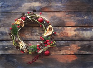 Christmas decoration on wooden background. Wreath with spice and red berries