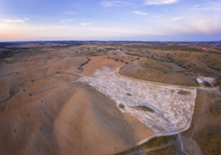 Drone aerial panorama of a desert like hill landscape with marble stones dust at sunset in Terena,