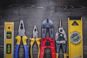 Tin snips steel cutter pliers construction level on wooden board