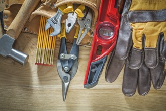 Tool belt with tooling construction level safety gloves on wooden board