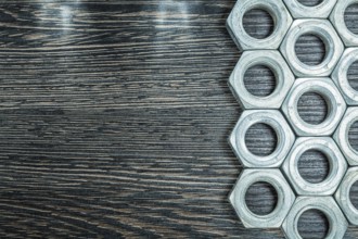 Stainless construction nuts on wooden board