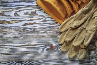 Leather protective gloves building belt on wooden board