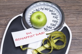 Concept photography for a healthy lifestyle with scales, apple and measuring tape
