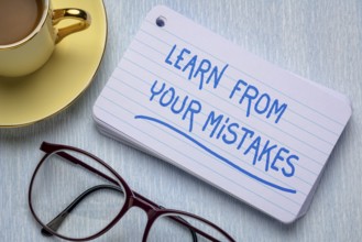 Learn from your mistakes - reminder on a stack of index cards with a cup of coffee, learning,