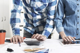 Designers working with color swatches and tablet computer at desk. Interior design, architectural