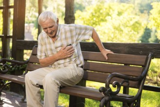 Senior guy has heartache. Elderly man on park bench. Too much stress. Chronic disease of heart