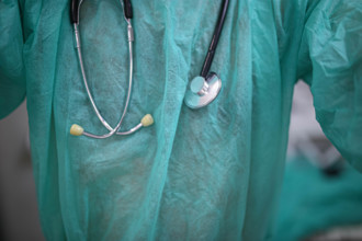 Close-up of a stethoscope over a green medical scrub