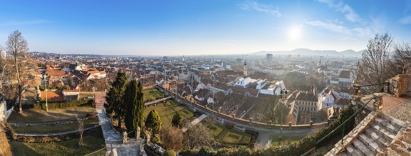 Wide panorama of Graz City, City rooftops, Mur river and city center, Schlossberg hill and clock