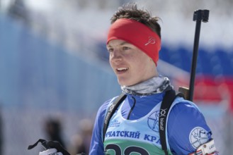 Portrait of sportsman biathlete Sporshev Nikita at finish after rifle shooting and skiing. Junior