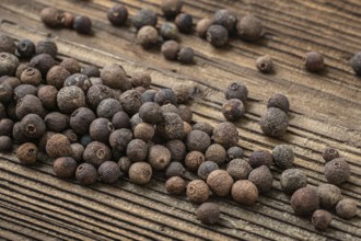 Allspice spice on dark rustic wooden background