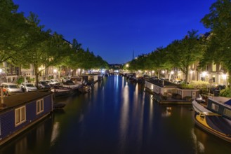 Night view of buildings and boats along the canal in Amsterdam, Netherlands